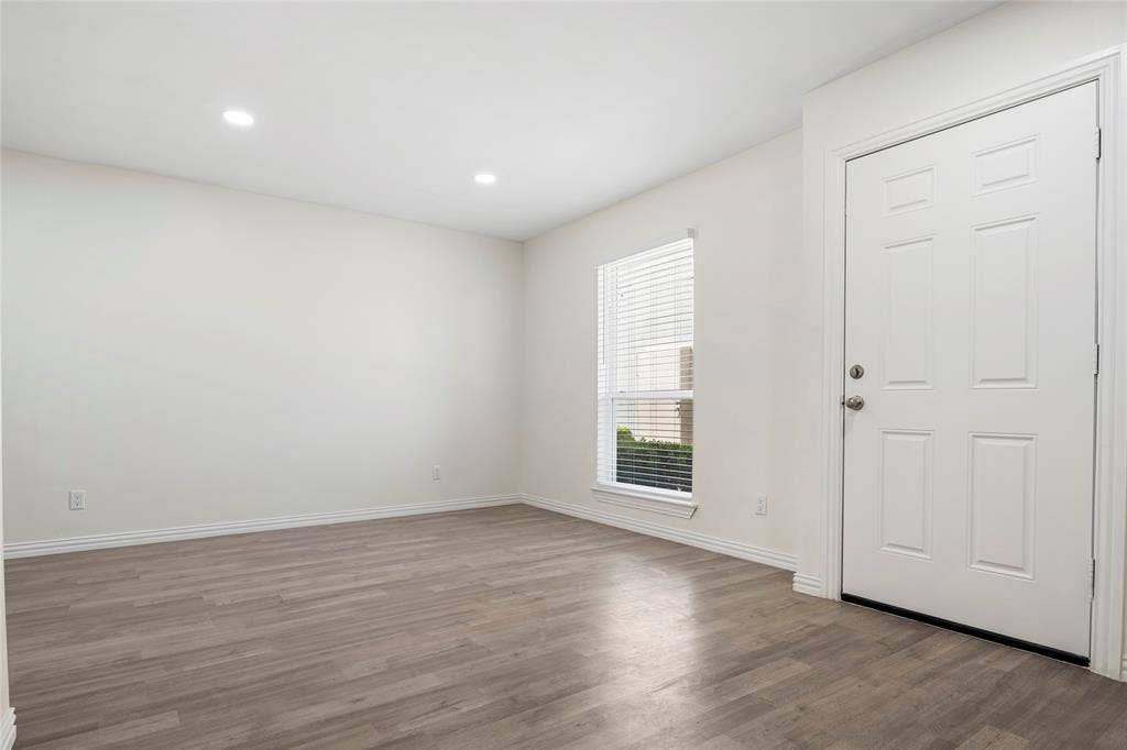 Entryway featuring a paneled door, wood-finish flooring, recessed lighting, and a window with blinds