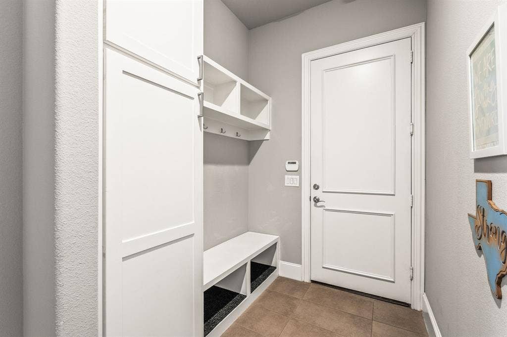 1640 Stillhouse Hollow Drive, Prosper, TX 75078 A hallway that leads from one of the garage bays has a built-in hall tree. It is off of the kitchen and gives privacy. The large pantry - not shown - is accessed off the hallway by the kitchen.