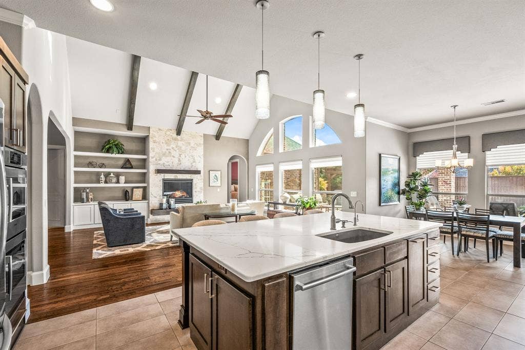 1640 Stillhouse Hollow Drive, Prosper, TX 75078 Open floor plan invites light. Note the living room beams, fully finished fireplace, built-in, designer lighting and architectural detail of the windows.