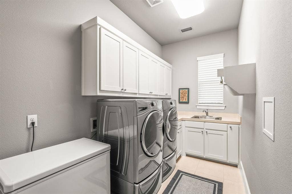 1640 Stillhouse Hollow Drive, Prosper, TX 75078 The laundry room fits a front load washer & dryer, room for a freezer or second refrigerator, good cabinet storage and a sink. Clothes folding area is by the sink near the appliances.