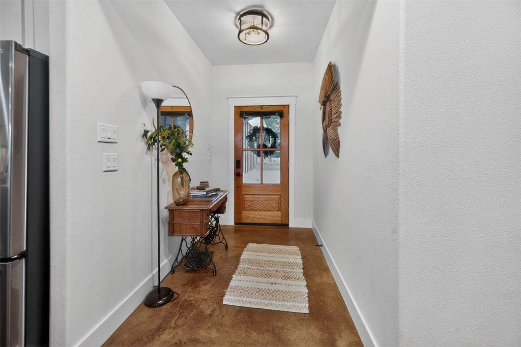 6371 Mill Run Road, Athens, TX 75751 Entryway featuring warm-toned flooring, a light wood door with glass panes, and a contemporary ceiling light fixture