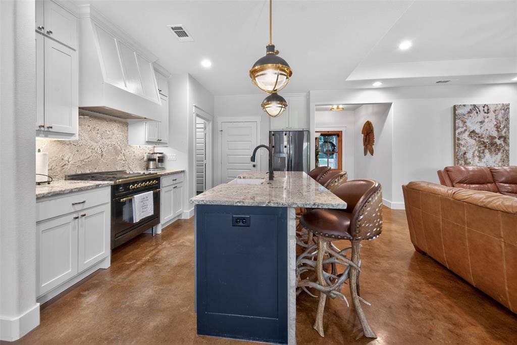 6371 Mill Run Road, Athens, TX 75751 The kitchen features white cabinetry, a dark blue island with a light-colored countertop, and a ILVE high end range
