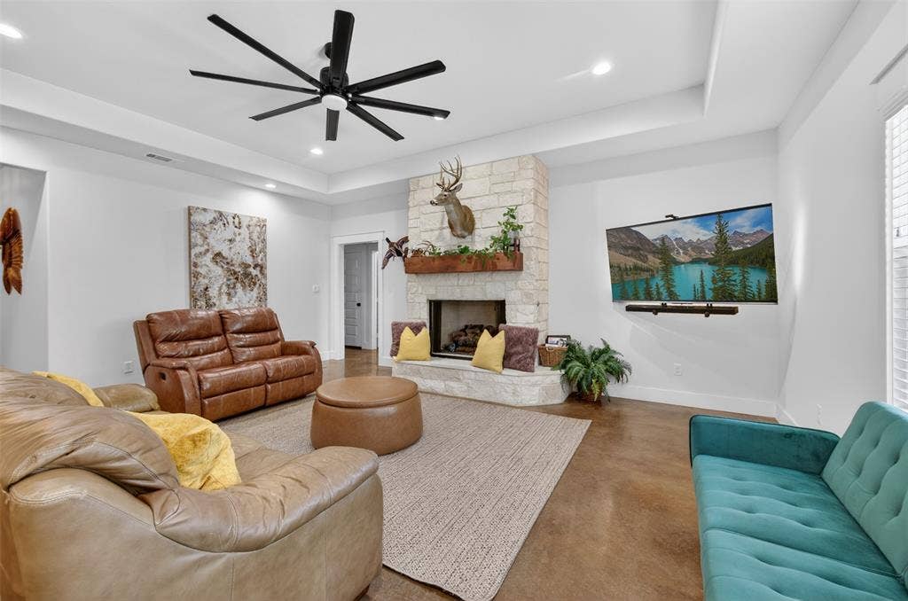 6371 Mill Run Road, Athens, TX 75751 Living area featuring a stone fireplace with a wooden mantel, a large ceiling fan, and recessed lighting