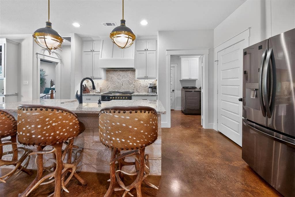 6371 Mill Run Road, Athens, TX 75751 The kitchen features a large island with a granite countertop and a stainless steel sink with a black gooseneck faucet