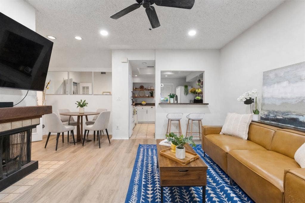 5590 Spring Valley Road, #C102, Dallas, TX 75254 cozy wood burning fireplace centrally located between living and dining spaces