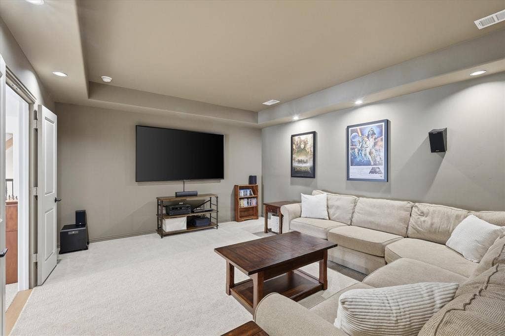 Spacious room featuring neutral wall paint, recessed lighting, and light-toned carpet flooring