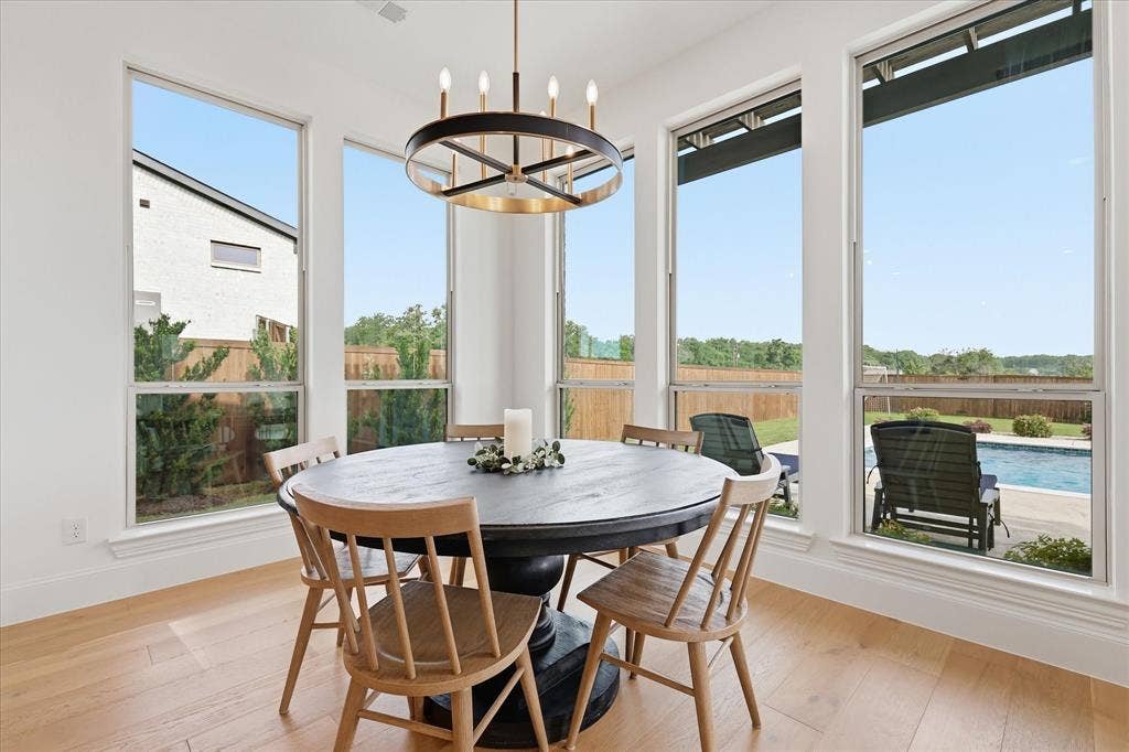 Dining area with light wood-finish flooring and a contemporary chandelier