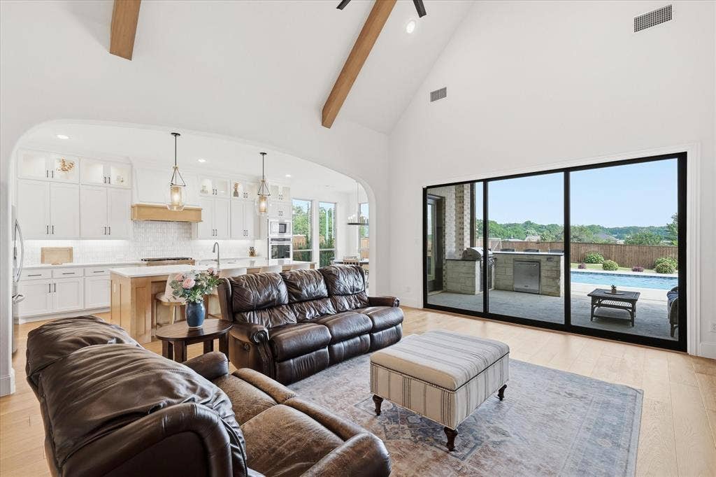 Vaulted living space with wood-finish flooring and exposed ceiling beams