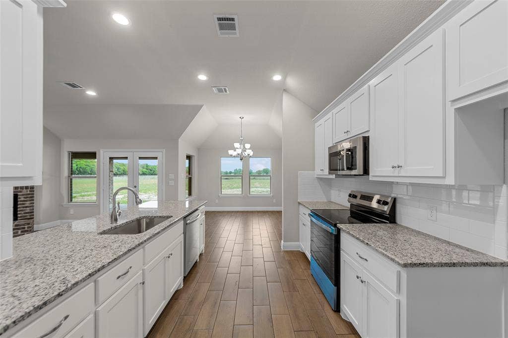 18310 CHIPPEWA Court, Terrell, TX 75160 Kitchen featuring a deep stainless steel sink, granite-style countertops, wood-finish flooring, white cabinetry, and stainless steel appliances