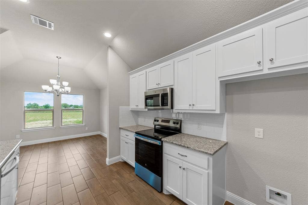 18310 CHIPPEWA Court, Terrell, TX 75160 Kitchen and dining area featuring white cabinetry, stainless steel appliances, granite countertops, and a white subway tile backsplash