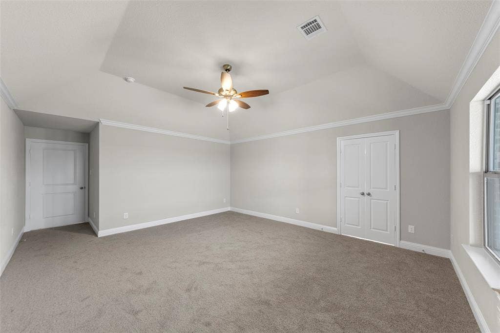 18310 CHIPPEWA Court, Terrell, TX 75160 Spacious room featuring vaulted ceilings, crown molding, a ceiling fan with integrated lighting, neutral wall tones, and carpet flooring