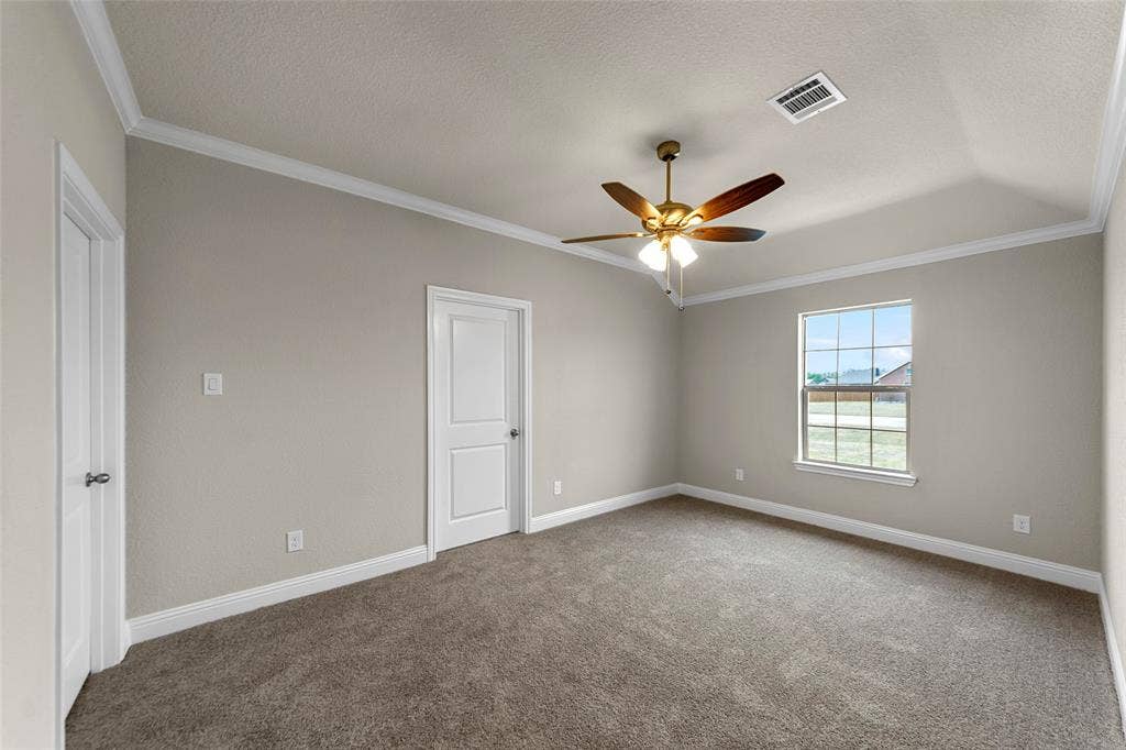18310 CHIPPEWA Court, Terrell, TX 75160 Carpeted room featuring a ceiling fan with light fixture, tray ceiling, crown molding, and white trim
