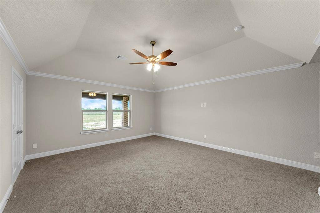 18310 CHIPPEWA Court, Terrell, TX 75160 Spacious room featuring vaulted ceilings, crown molding, a ceiling fan, and carpeted flooring