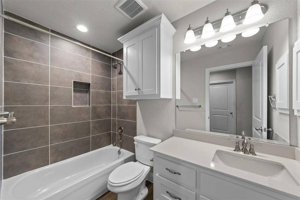 18310 CHIPPEWA Court, Terrell, TX 75160 Bathroom featuring a white vanity with an integrated sink and brushed nickel faucet, a large mirror, and a five-light fixture