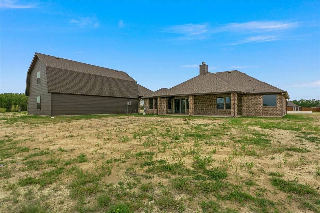 18310 CHIPPEWA Court, Terrell, TX 75160 New construction home featuring brick exterior, covered patio, and a separate two-story structure with siding