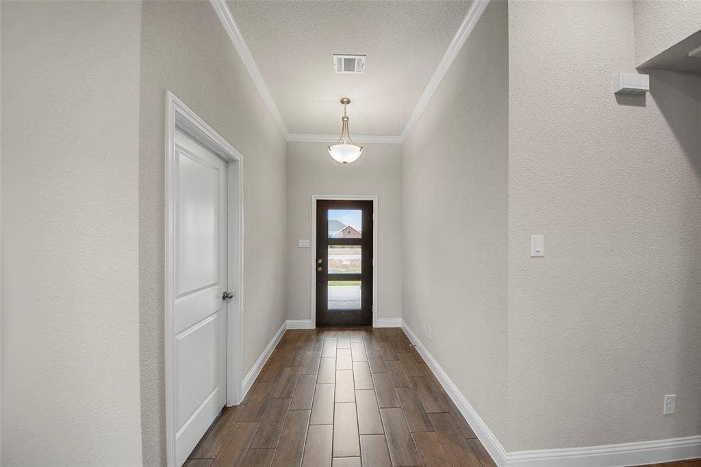 18310 CHIPPEWA Court, Terrell, TX 75160 Hallway featuring wood-finish tile flooring, a two-panel interior door, and crown molding