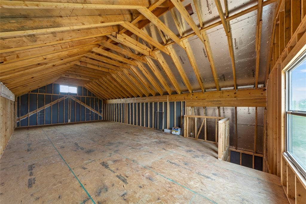 18310 CHIPPEWA Court, Terrell, TX 75160 Unfinished bonus room featuring exposed wood framing, a wide window, and a smaller dormer window