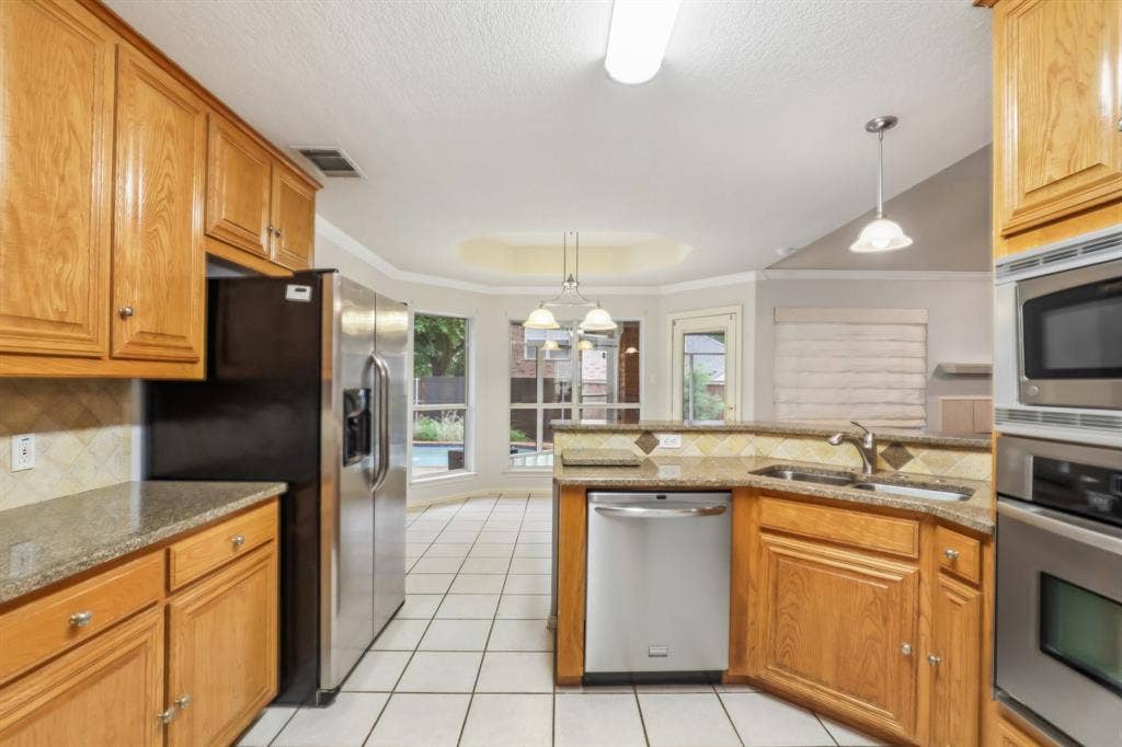 4124 Cory Lee Court, Arlington, TX 76015 Kitchen featuring light wood cabinetry, granite countertops, stainless steel appliances, and tile flooring