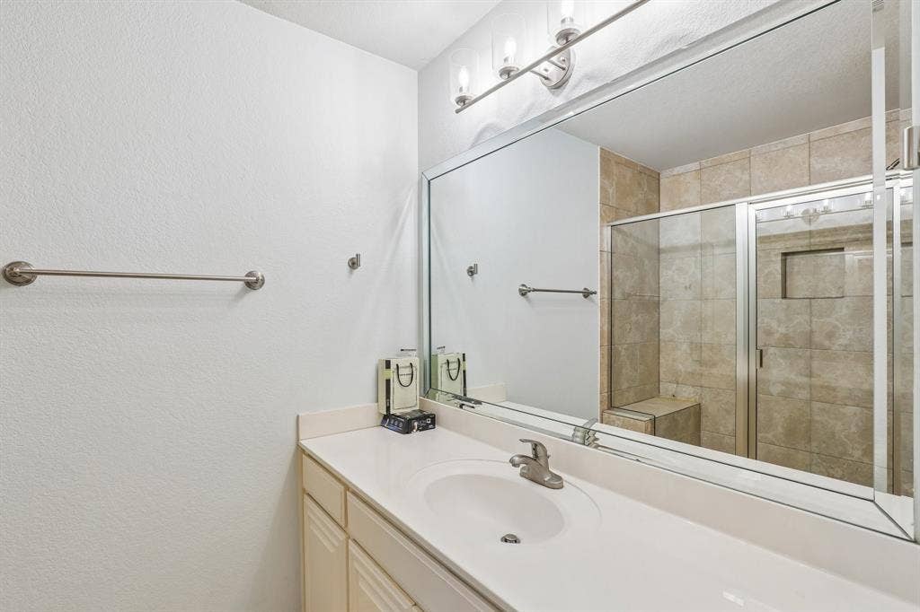 4124 Cory Lee Court, Arlington, TX 76015 Bathroom vanity with an integrated sink, brushed nickel faucet, and a large wall-mounted mirror