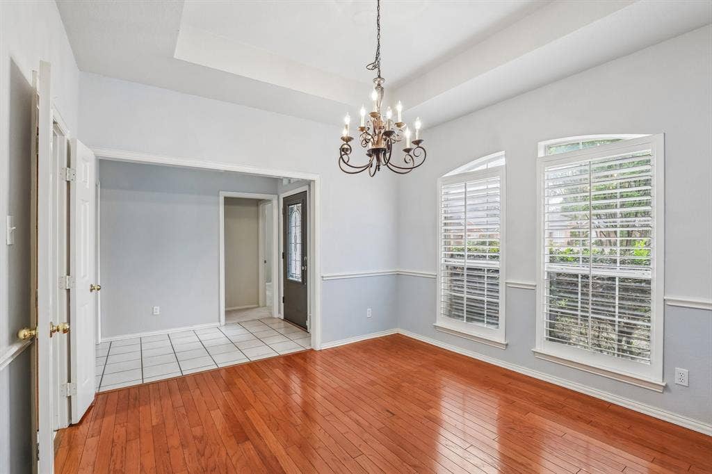 4124 Cory Lee Court, Arlington, TX 76015 Spacious room featuring wood-finish flooring, a tray ceiling, and a chandelier