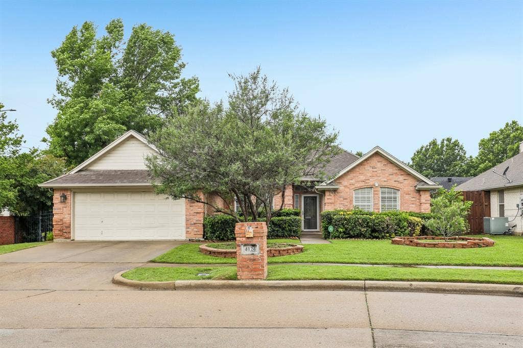 4124 Cory Lee Court, Arlington, TX 76015 Brick facade residence featuring a two-car garage, mature landscaping, and an inviting front entrance