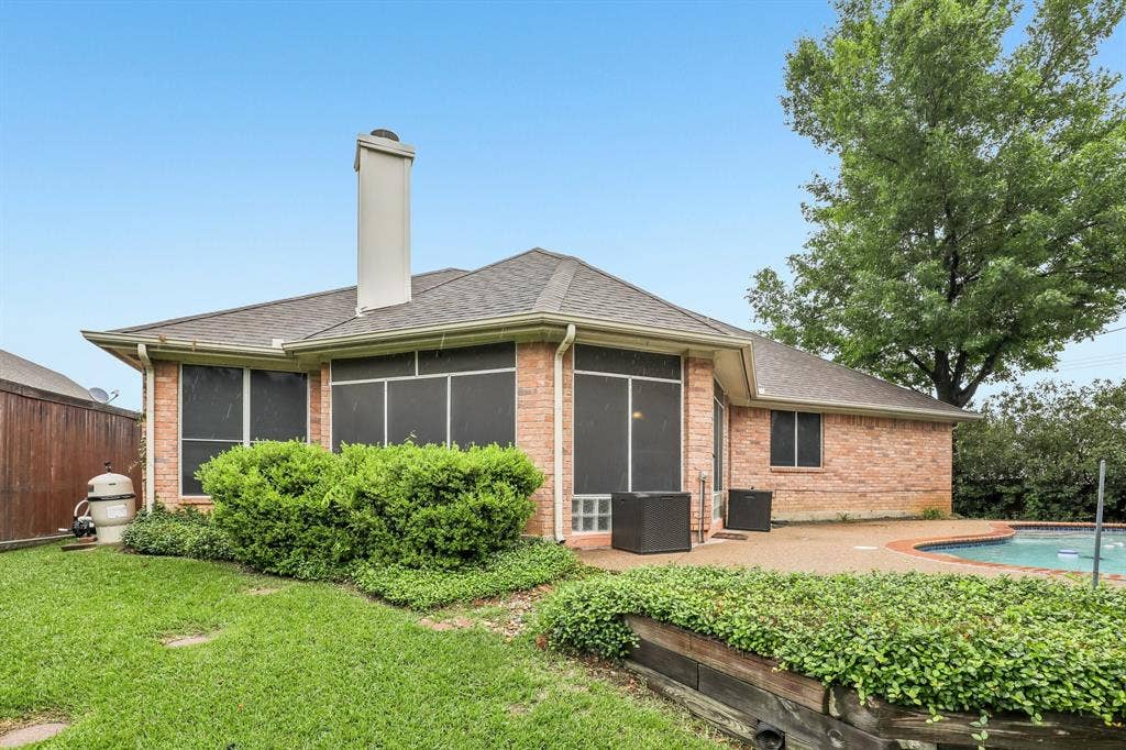 4124 Cory Lee Court, Arlington, TX 76015 Brick exterior with a gabled roofline, a screened-in porch, and an in-ground swimming pool