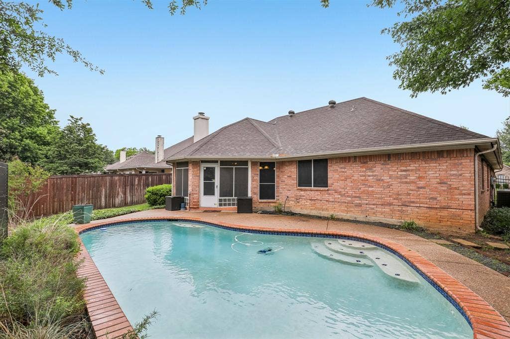 4124 Cory Lee Court, Arlington, TX 76015 Curved swimming pool with integrated steps, brick coping, and surrounding concrete deck