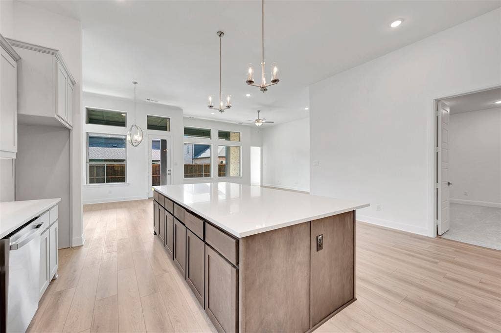 1611 Cedarberry Drive, Northlake, TX 76226 Central kitchen island with white countertop, light wood-finish flooring, recessed lighting, and modern pendant light fixtures