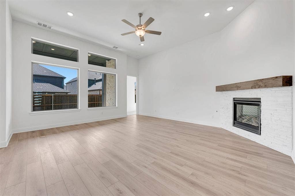 1611 Cedarberry Drive, Northlake, TX 76226 Spacious room featuring vaulted ceilings, a contemporary fireplace with a wood mantel, wood-finish flooring, and recessed lighting