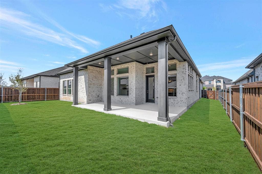 1611 Cedarberry Drive, Northlake, TX 76226 Expansive rear yard featuring a covered patio, brick exterior, dark trim, and a privacy fence