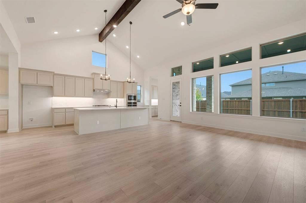 1605 Cedarberry Drive, Northlake, TX 76226 Expansive open-concept space featuring wood-finish flooring, a vaulted ceiling with an exposed beam, and recessed lighting