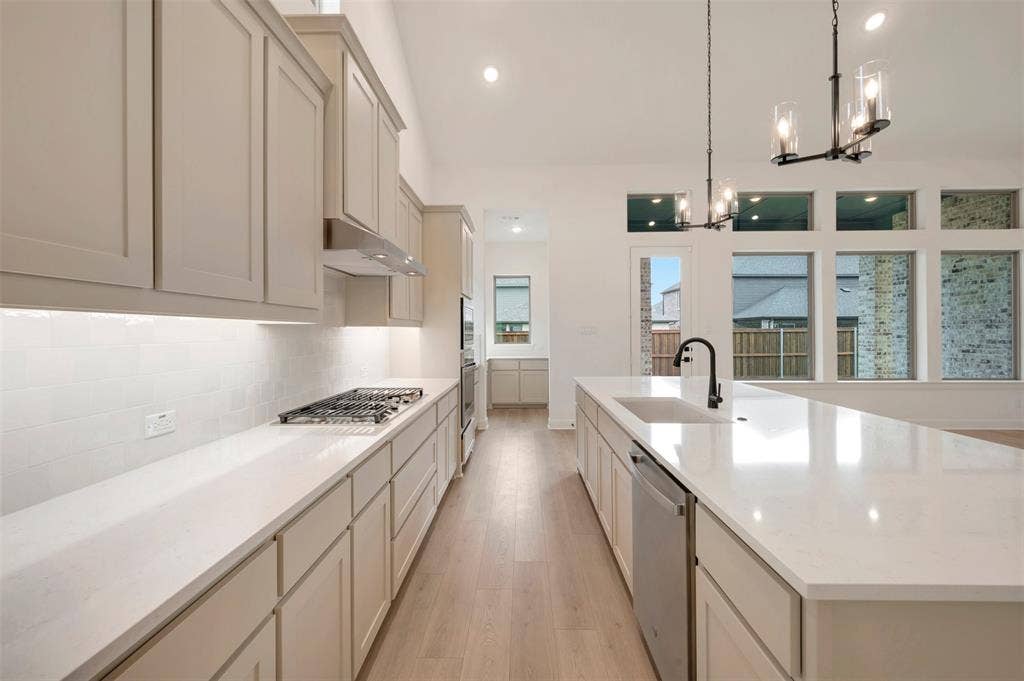 1605 Cedarberry Drive, Northlake, TX 76226 Chef's kitchen featuring custom cabinetry with integrated hardware, quartz countertops, a gas cooktop with stainless steel hood, and a large center island with waterfall edge