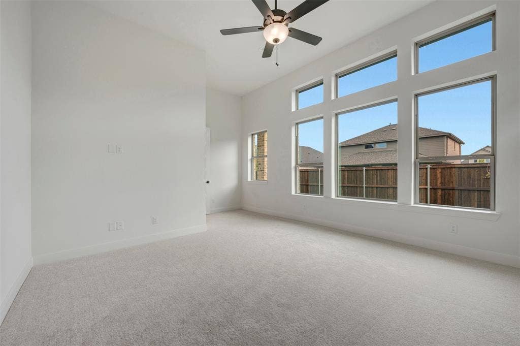 1605 Cedarberry Drive, Northlake, TX 76226 High ceilings with a ceiling fan light fixture, expansive windows, light-colored carpeting, and white painted walls