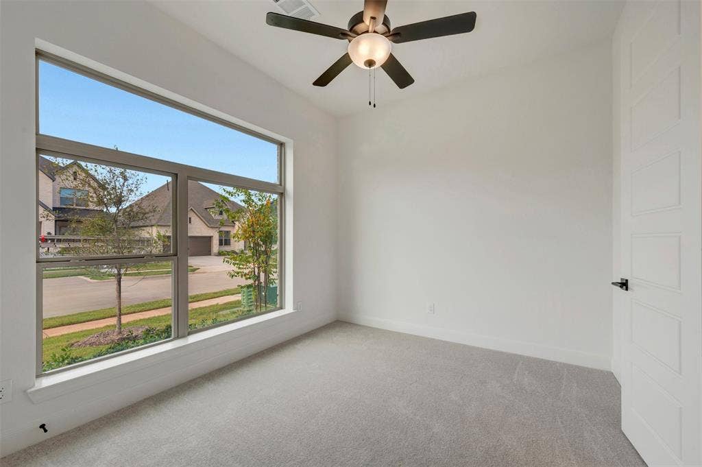 1605 Cedarberry Drive, Northlake, TX 76226 Expansive window offering abundant natural light, ceiling fan with integrated lighting, light-toned carpeting, and a contemporary paneled door with dark hardware