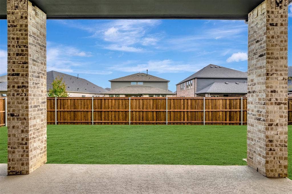 1605 Cedarberry Drive, Northlake, TX 76226 Expansive backyard featuring a manicured lawn, wood fencing, and a concrete patio with brick columns