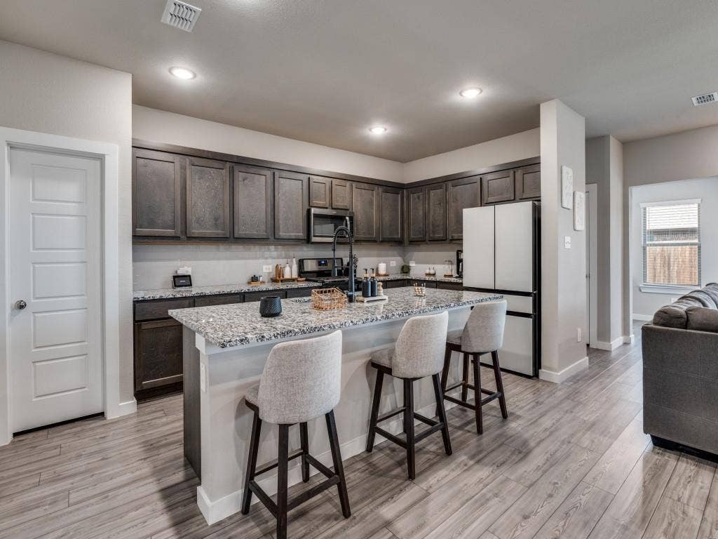 626 Congressional Avenue, Red Oak, TX 75154 Well-appointed kitchen featuring wood-finish flooring, dark wood cabinetry, and light-toned countertops
