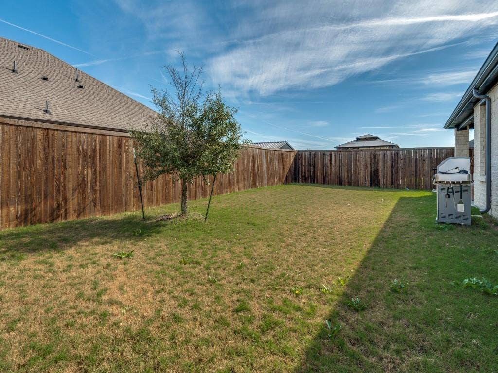 626 Congressional Avenue, Red Oak, TX 75154 Expansive backyard featuring a partial grass lawn, full perimeter wood fencing, and a young tree