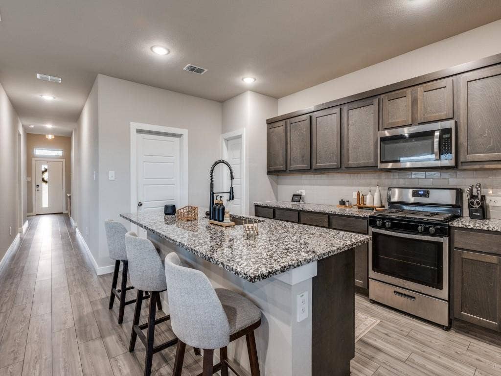 626 Congressional Avenue, Red Oak, TX 75154 Contemporary kitchen with an island featuring a dark base and a speckled countertop