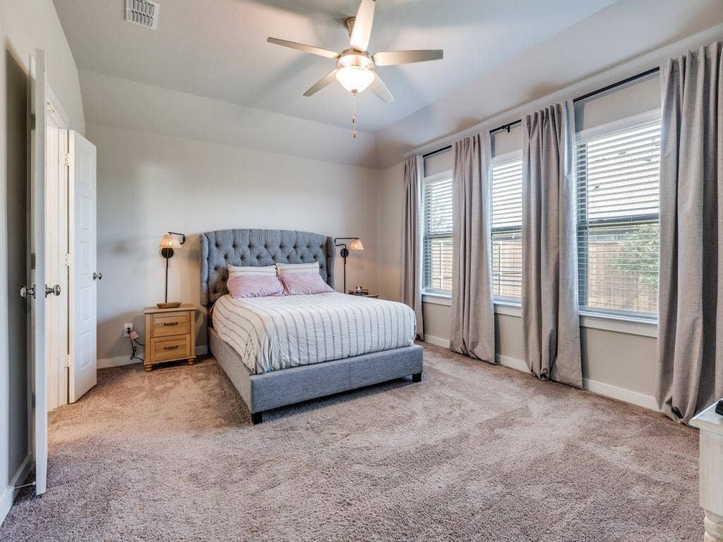 626 Congressional Avenue, Red Oak, TX 75154 Carpeted room featuring a ceiling fan with light, multiple windows with blinds and drapery, and a white paneled door