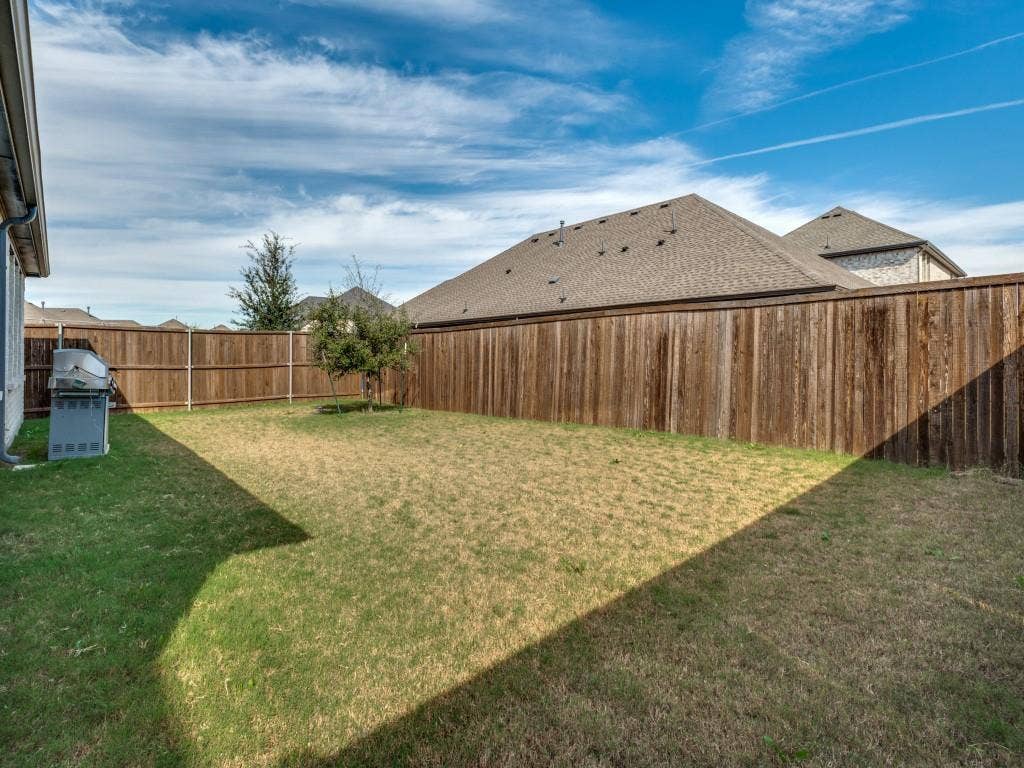 626 Congressional Avenue, Red Oak, TX 75154 Spacious backyard featuring a full wood privacy fence and a young tree