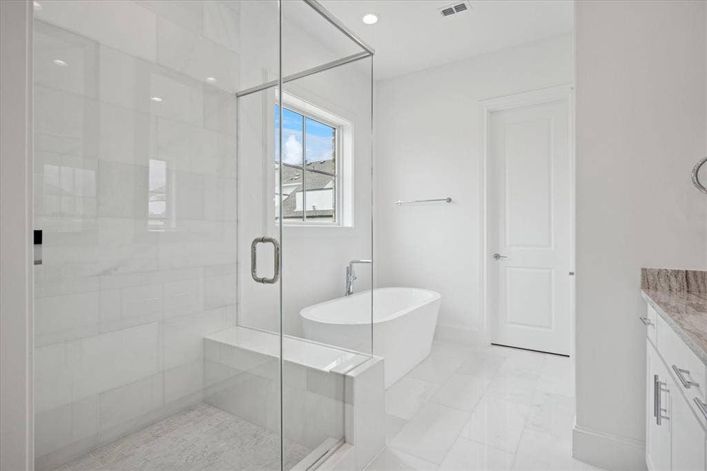 14956 Oak Street, Addison, TX 75001 Glass-enclosed shower with white tiled walls and built-in bench