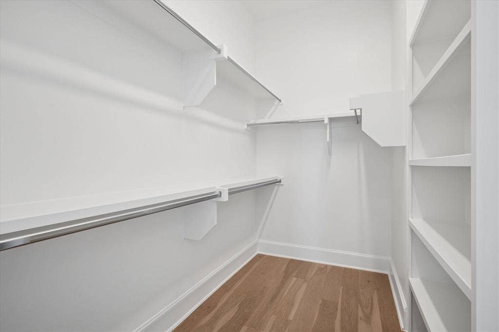 14956 Oak Street, Addison, TX 75001 Walk-in closet featuring built-in shelving, two hanging rods, and wood-finish flooring