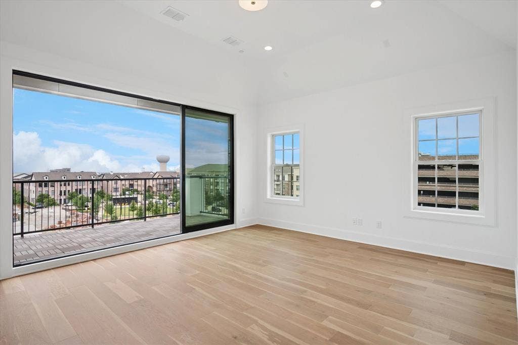 14956 Oak Street, Addison, TX 75001 Spacious room featuring light wood-finish flooring, white walls, and a recessed lighting fixture