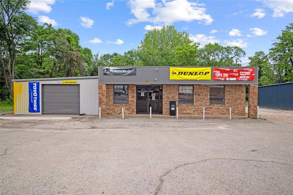 807 W Corsicana Street, Athens, TX 75751 Commercial building featuring a brick facade and a gray roll-up garage door