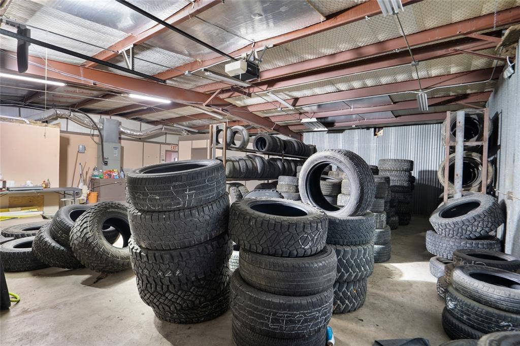 807 W Corsicana Street, Athens, TX 75751 Industrial interior featuring exposed metal beams, concrete flooring, fluorescent lighting, and corrugated metal wall paneling