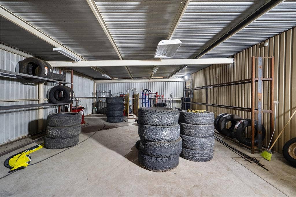 807 W Corsicana Street, Athens, TX 75751 Utility room featuring corrugated metal walls and ceiling, concrete flooring, and fluorescent lighting fixtures