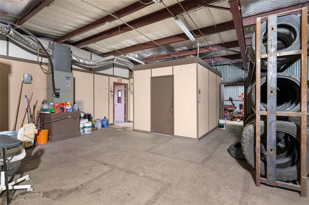 807 W Corsicana Street, Athens, TX 75751 Warehouse interior featuring exposed steel beams, concrete flooring, and suspended fluorescent lighting