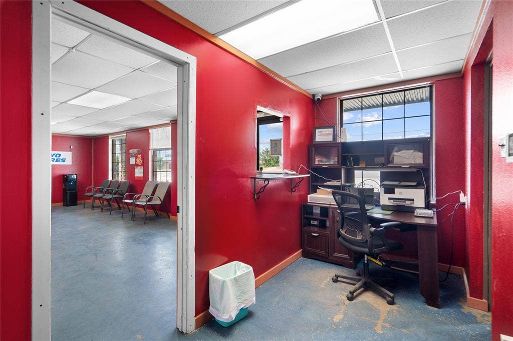 807 W Corsicana Street, Athens, TX 75751 Reception area featuring a service window, drop ceiling with fluorescent lighting, and a large window