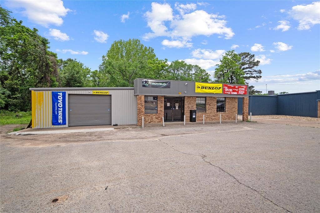 807 W Corsicana Street, Athens, TX 75751 Commercial building featuring a brick facade with multiple window openings and a prominent storefront entrance