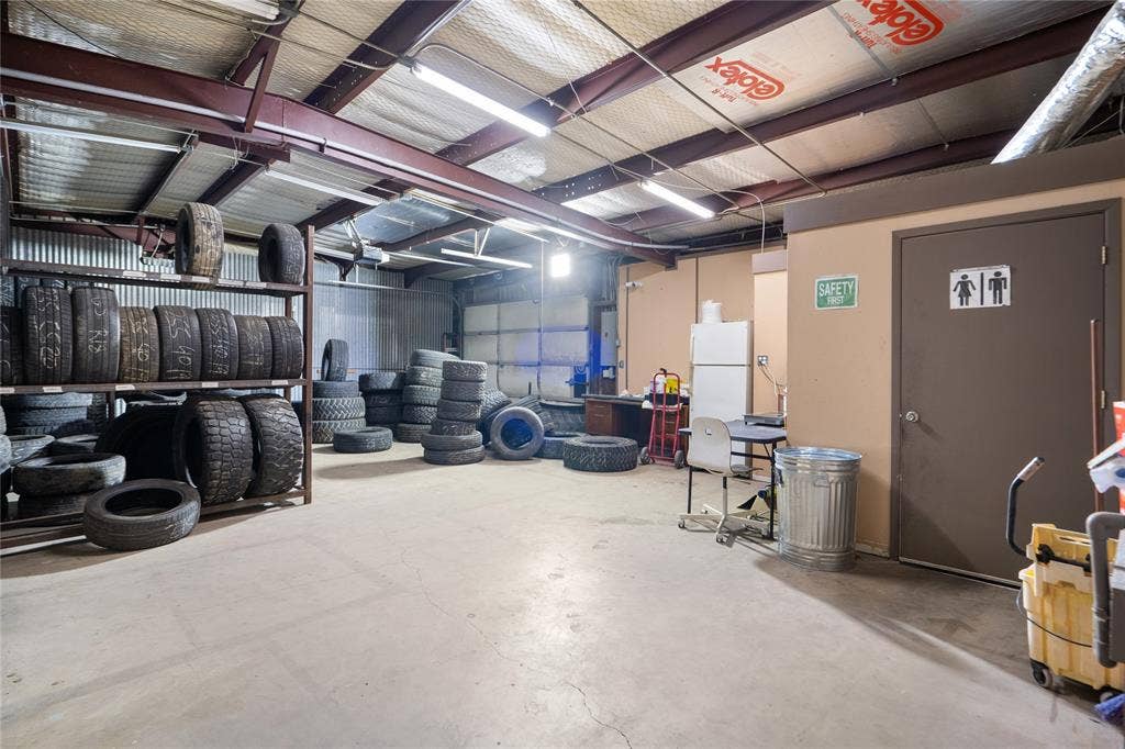 807 W Corsicana Street, Athens, TX 75751 Spacious commercial interior featuring concrete flooring, exposed metal beam construction, and fluorescent lighting